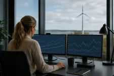 En analytiker vid ett skrivbord med skärmar som visar diagram över elproduktion