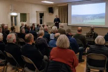 Samrådsmöte i en bygdegård med åhörare som lyssnar på en presentatör